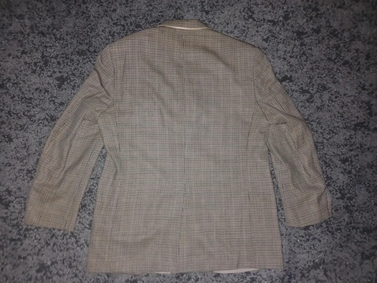 Veste blazer classique en tweed à deux boutons pour homme par Lauren Ralph Lauren, dans un motif micro-pied-de-poule complexe beige, marron et marine. Initialement vendue chez Macy's Men's Store. Marque : Lauren Ralph Lauren Taille : Large (L) Couleur : Micro-carreaux beige, havane, marron et marine Motif : Pied-de-poule / Tweed Guncheck Matière : Extérieur tissé en laine / mélange de laine avec doublure intérieure complète Caractéristiques : Fermeture à deux boutons sur le devant, revers crantés, poignets à quatre boutons, poche poitrine passepoilée, poches à rabat pour les mains, doubles poches intérieures à la poitrine et fente simple au dos État : Excellent état d'occasion, texture tissée nette, doublure complète propre, boutons intacts et les deux étiquettes de marque intérieures entièrement présentes. 3