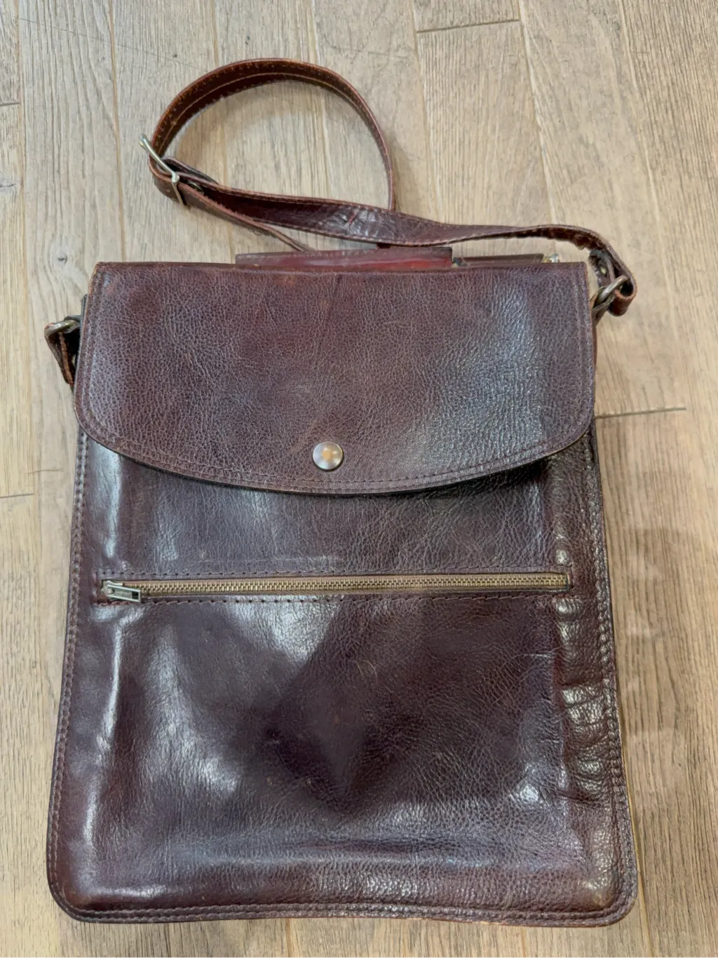 Sacoche en cuir marron vintage avec fermoir en laiton et poches avant, dotée d'une bandoulière ajustable. 2