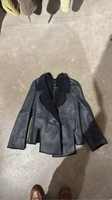 Veste en cuir noire Theyskens Theory avec col en matière duveteuse et ourlet asymétrique. Olivier Theyskens