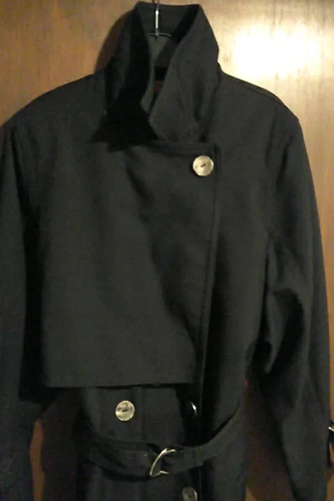 Trench noir , très sympa, doublure à l'intérieur.T40/42. Manche 3/4, elles peuvent se resserrer grâce aux anneaux, ou desserrer(voir dernière photos). 3