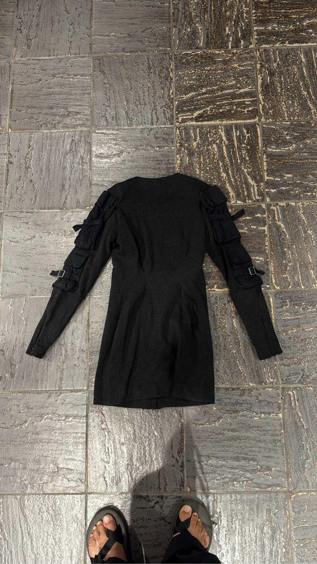 Robe courte grise à manches longues avec des détails de poches cargo et boucles sur les manches, et une fermeture éclair frontale. 4