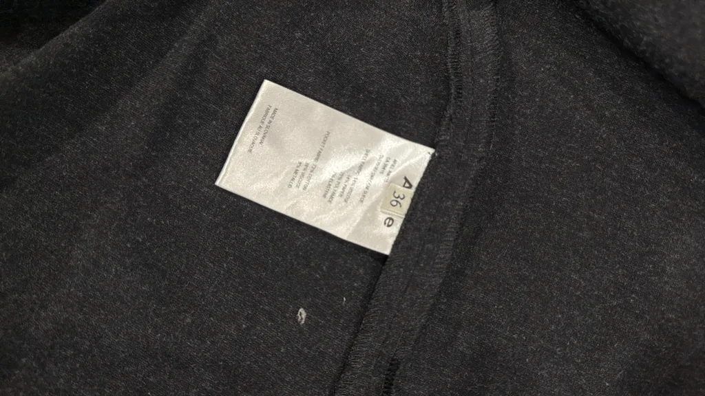 Robe courte grise à manches longues avec des détails de poches cargo et boucles sur les manches, et une fermeture éclair frontale. 5