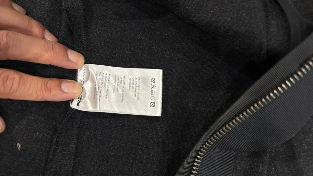 Robe courte grise à manches longues avec des détails de poches cargo et boucles sur les manches, et une fermeture éclair frontale. 6