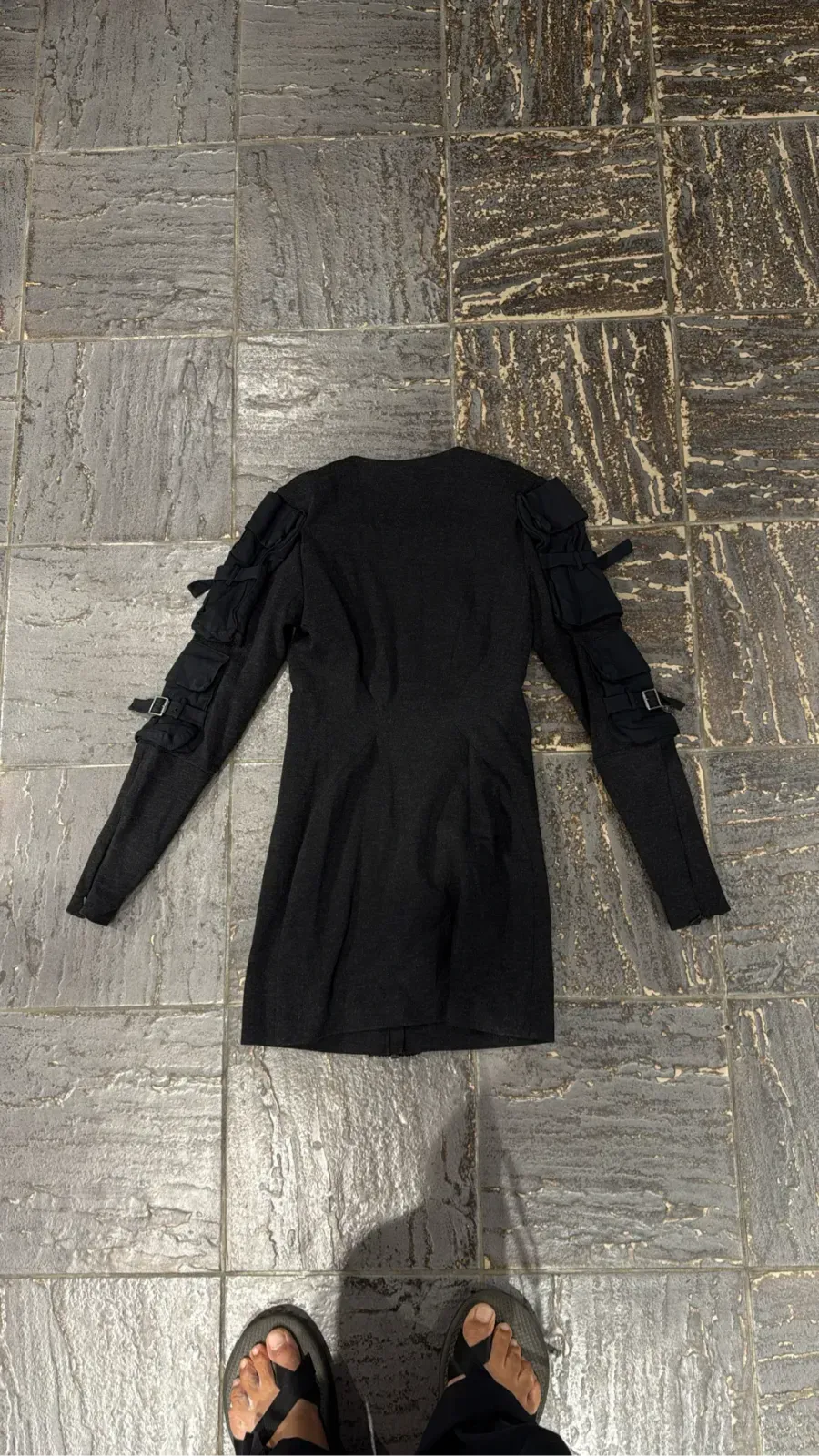 Short grey long-sleeve dress with cargo pocket details, buckles on the sleeves and a front zip. 4
