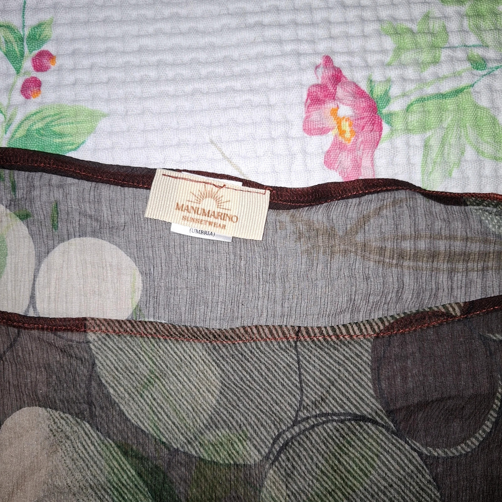 Splendide tunique de plage signée ManuMarino (ligne Sunsetwear, fabriquée en Ombrie). Pièce confectionnée à la main avec un précieux artisanat en 90% soie, très légère et impalpable sur la peau. Caractérisée par un motif abstrait raffiné à cercles et des profils contrastants couleur terre cuite qui se transforment en ceinture pour souligner la taille. S'adapte magnifiquement aux tailles M et L grâce à sa coupe fluide. État impeccable, comme neuve. Une pièce exclusive et artisanale idéale pour un look de plage sophistiqué et élégant. 3