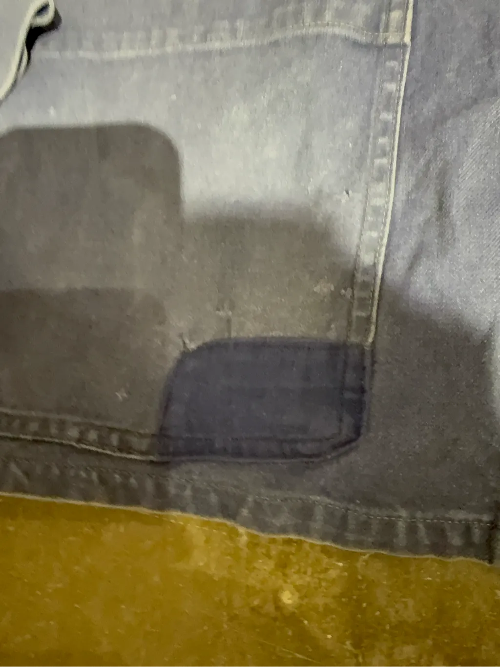 Veste de travail vintage bleue en coton, avec des poches plaquées, une usure authentique et un patch de réparation visible sur une poche. 4