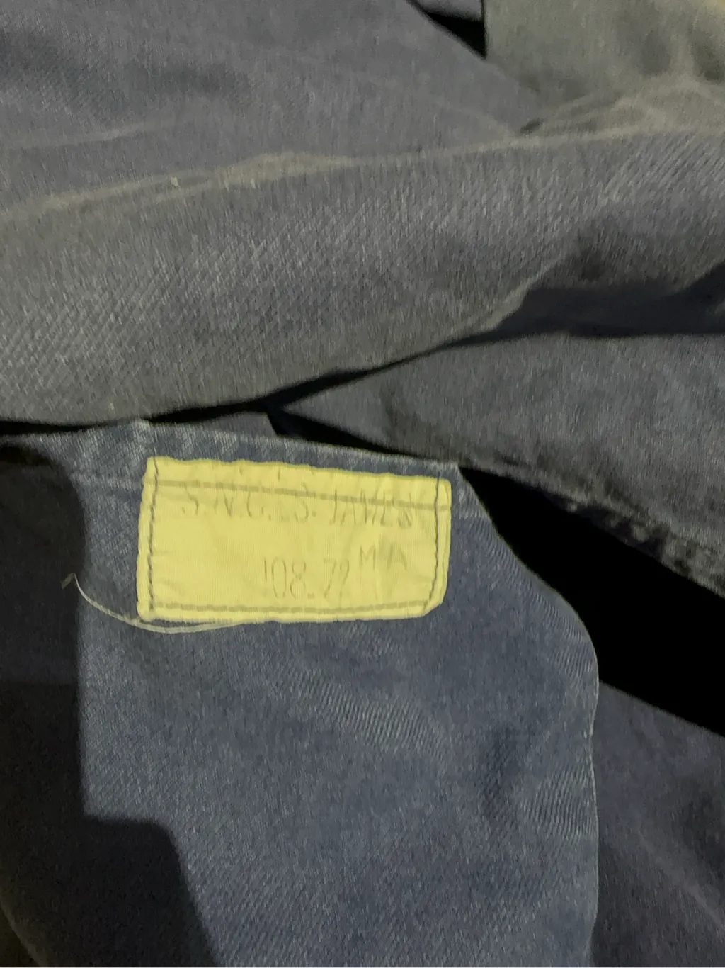 Veste de travail vintage bleue en coton, avec des poches plaquées, une usure authentique et un patch de réparation visible sur une poche. 6