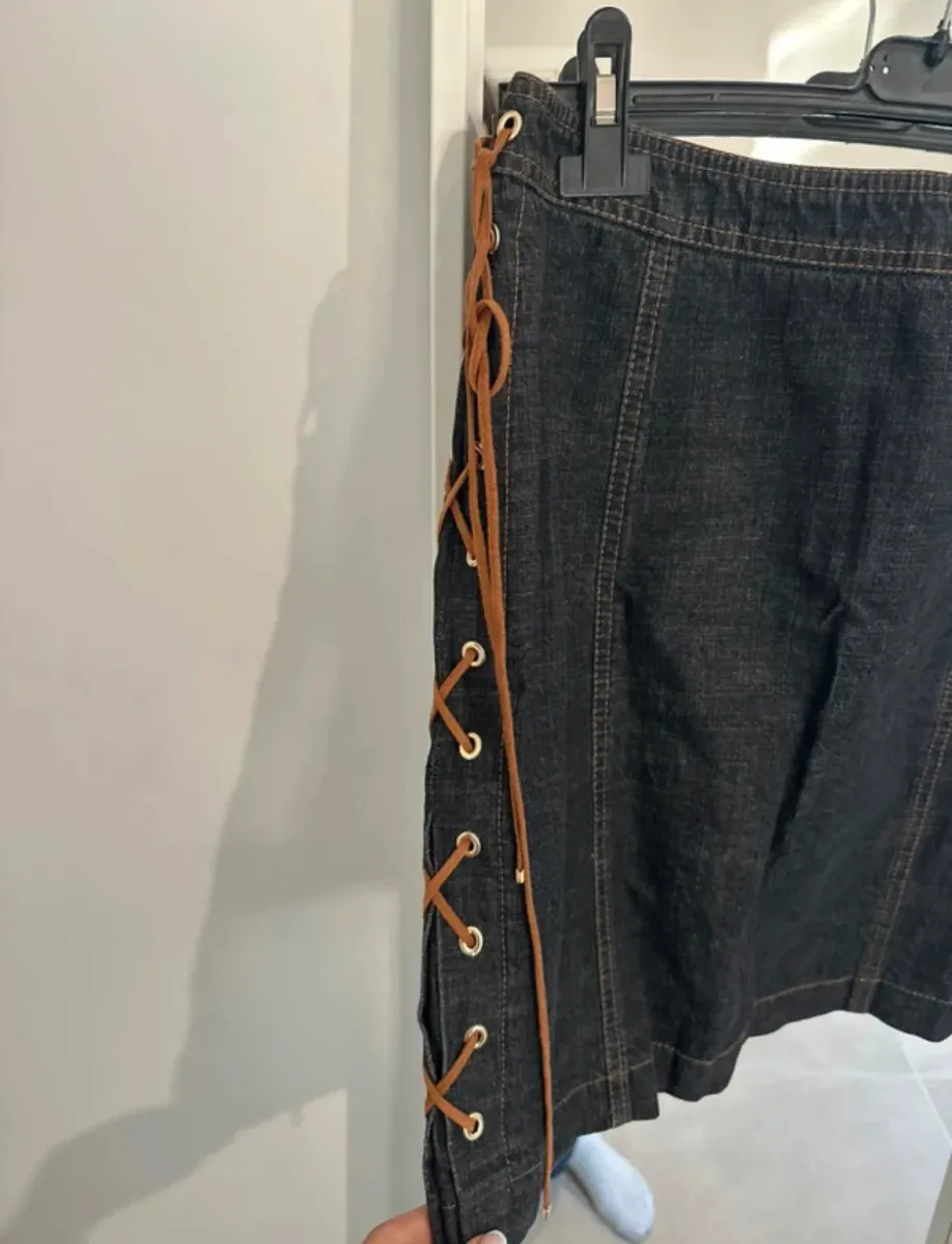 Jupe en jean Escada noire, taille 36, avec détails de lacets latéraux. Une pièce vintage intemporelle en excellent état.