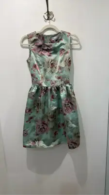 Robe de cocktail Mademoiselle Tara by Tara Jarmon sans manches à imprimé floral vert clair et rose, avec une coupe cintrée et une jupe évasée.