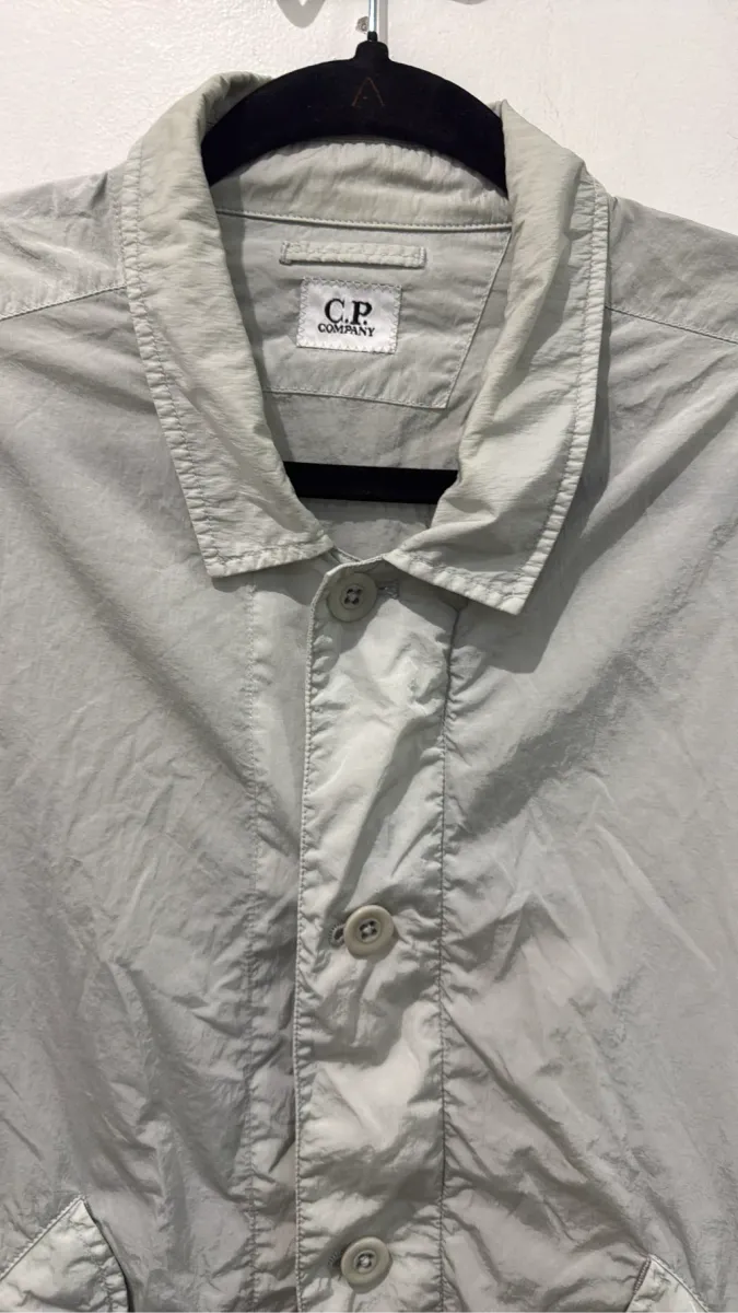 Chemise-veste à manches courtes C.P. Company en nylon recyclé Chrome-R, de couleur gris clair, avec un patch logo sur la manche. 2