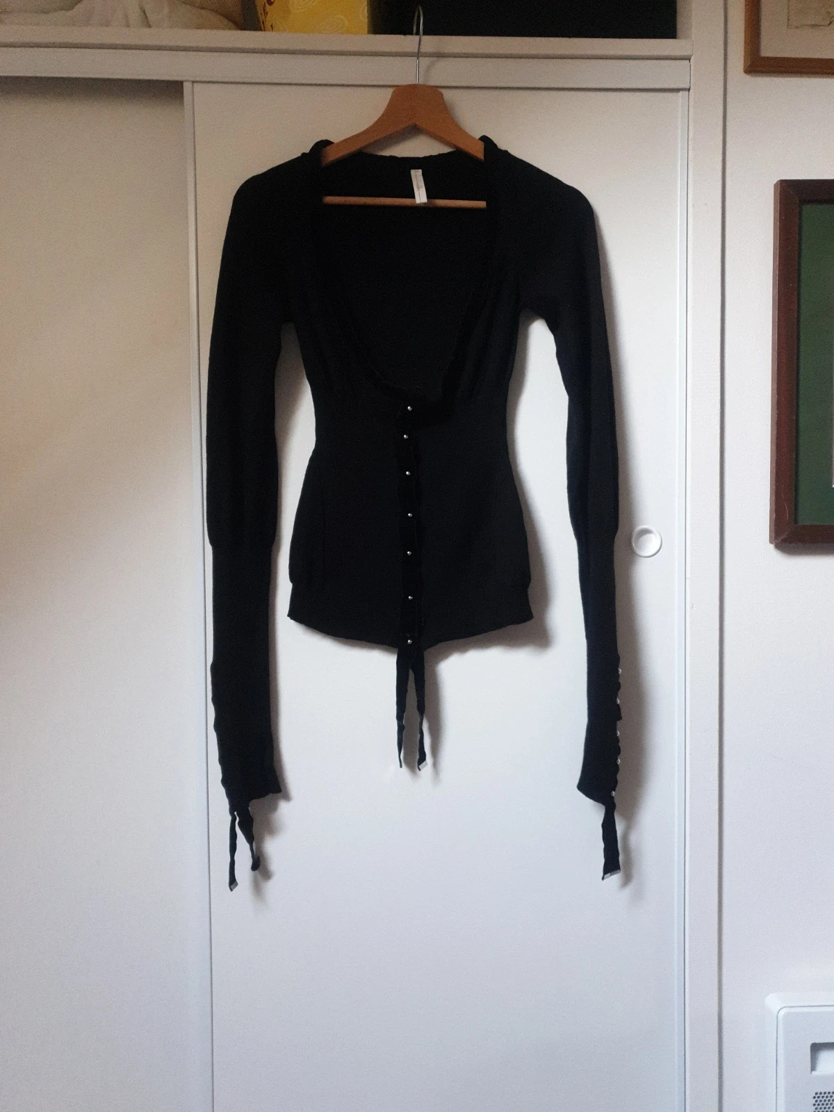 Magnifique et authentique pull noir de la célèbre marque italienne high use. Élégant, seyant et chaud à porter sur une chemise ou en gilet. De riches détails, des manches très longues agrémentées de beaux rubans et de jolis boutons pressions. Une touche chic et tendance pour un look original et unique. Taille 38. Envoi uniquement par chronopost,mondial relay et colissimo.
