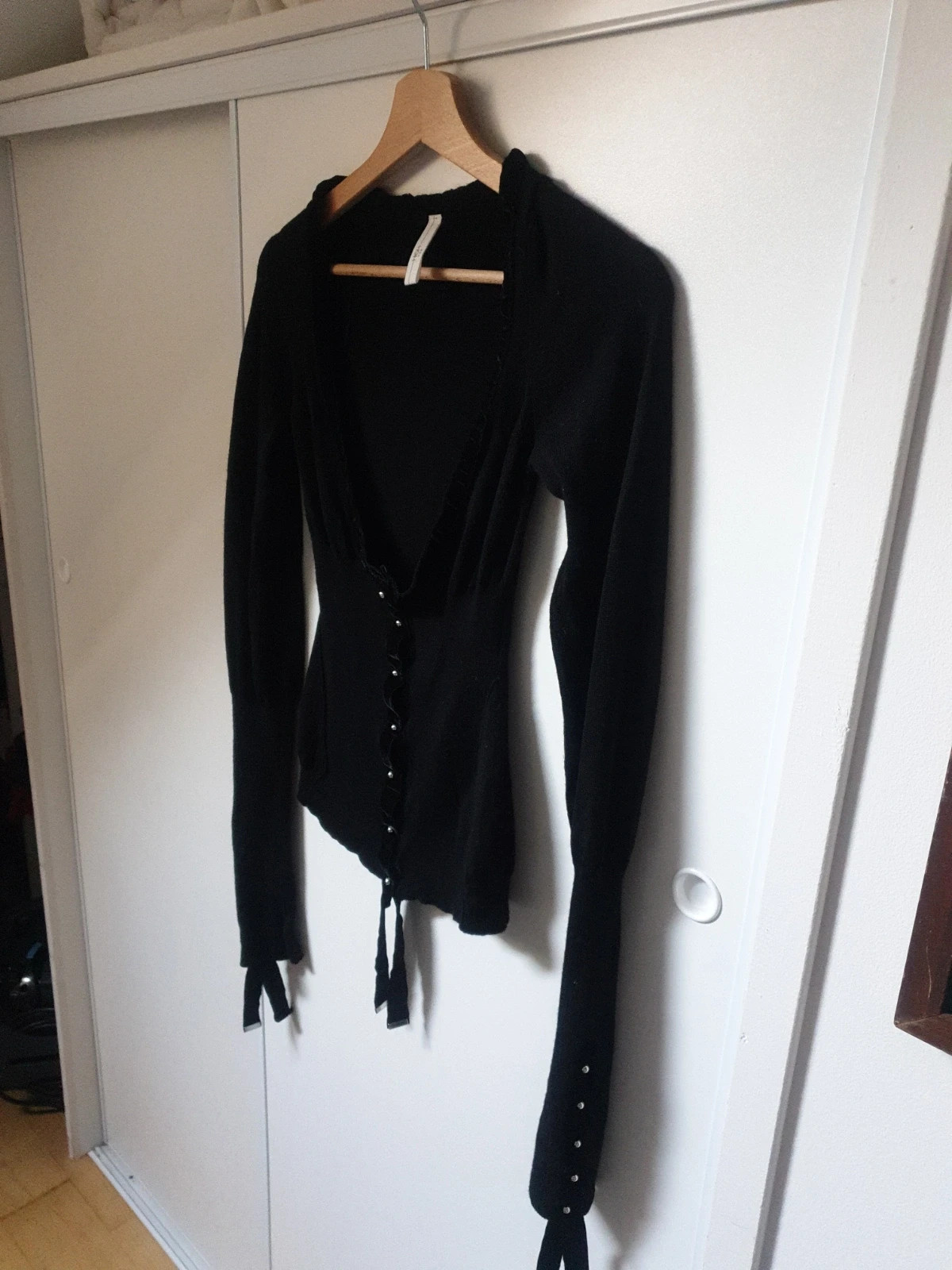 Magnifique et authentique pull noir de la célèbre marque italienne high use. Élégant, seyant et chaud à porter sur une chemise ou en gilet. De riches détails, des manches très longues agrémentées de beaux rubans et de jolis boutons pressions. Une touche chic et tendance pour un look original et unique. Taille 38. Envoi uniquement par chronopost,mondial relay et colissimo. 8