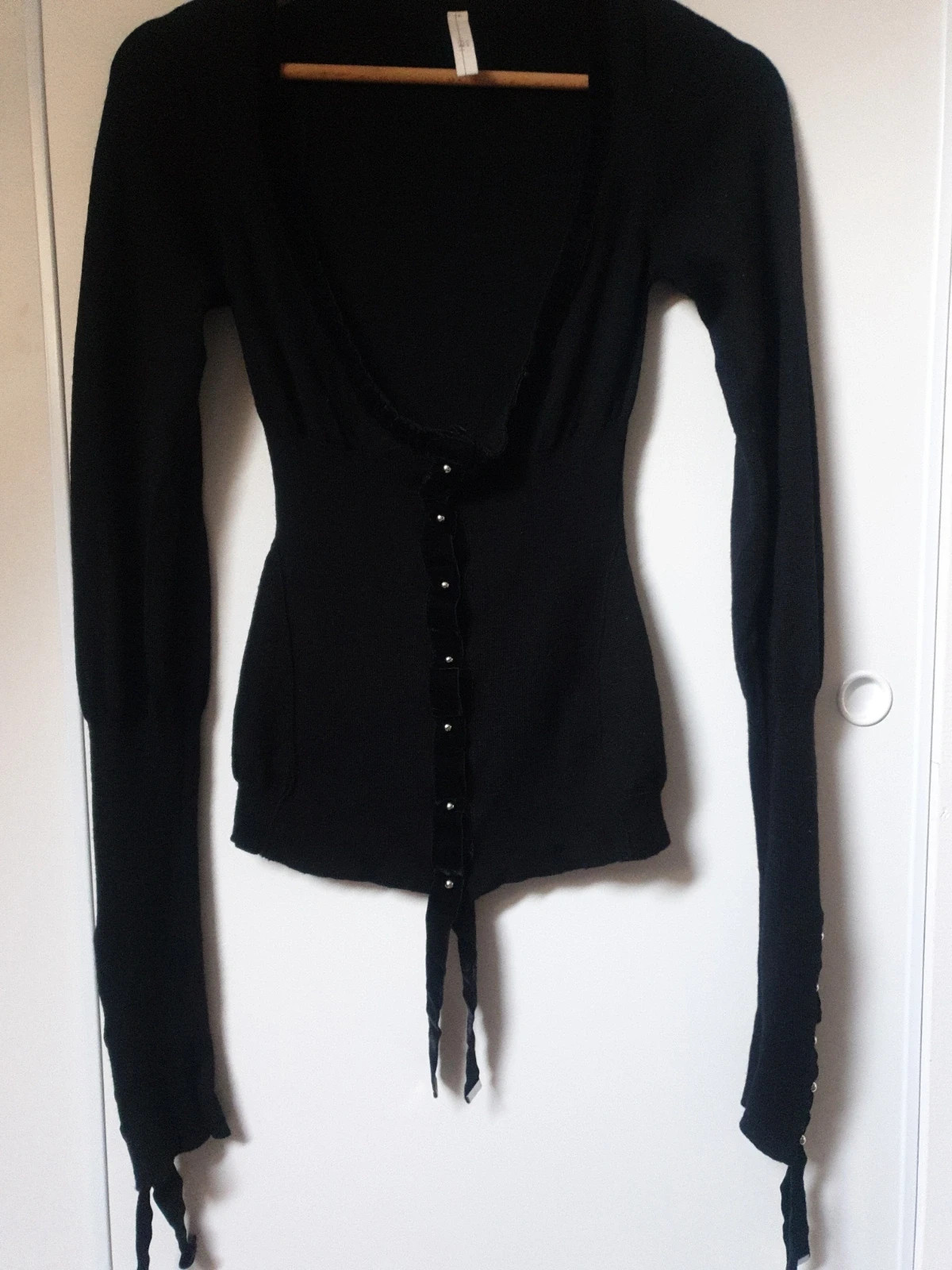 Magnifique et authentique pull noir de la célèbre marque italienne high use. Élégant, seyant et chaud à porter sur une chemise ou en gilet. De riches détails, des manches très longues agrémentées de beaux rubans et de jolis boutons pressions. Une touche chic et tendance pour un look original et unique. Taille 38. Envoi uniquement par chronopost,mondial relay et colissimo. 2