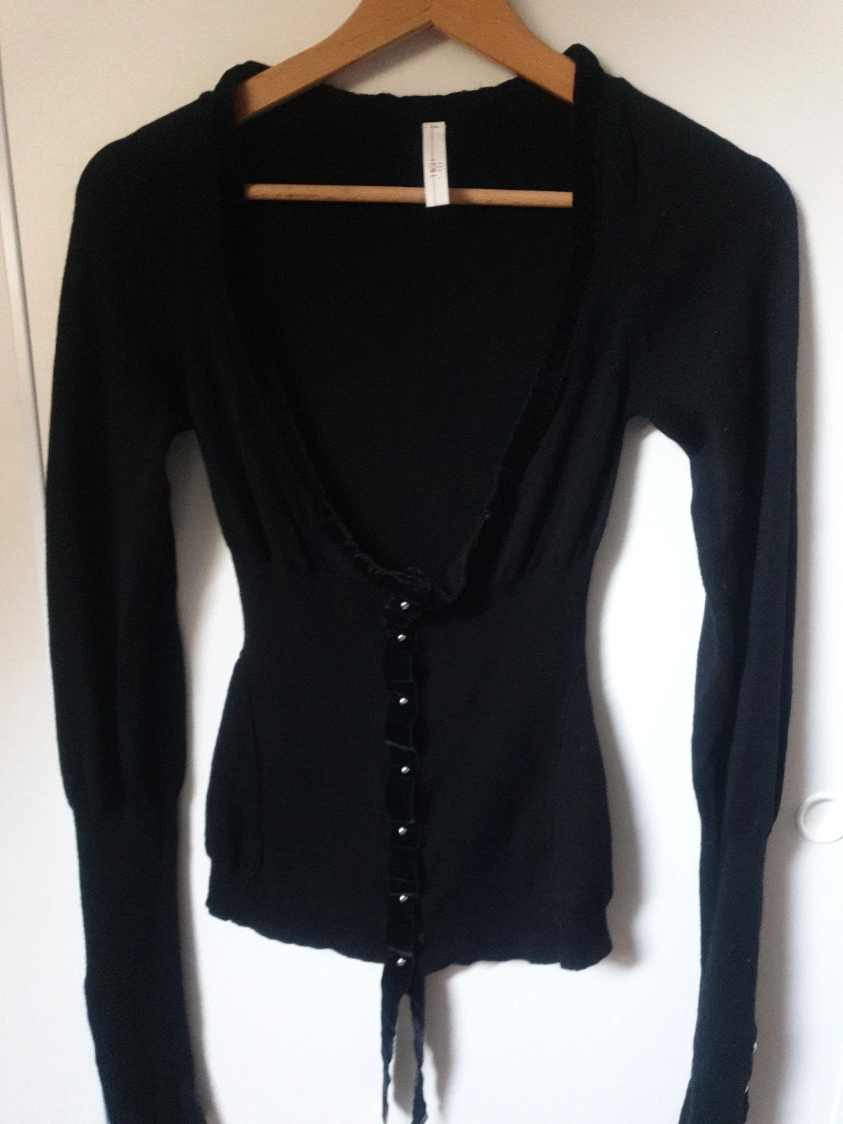 Magnifique et authentique pull noir de la célèbre marque italienne high use. Élégant, seyant et chaud à porter sur une chemise ou en gilet. De riches détails, des manches très longues agrémentées de beaux rubans et de jolis boutons pressions. Une touche chic et tendance pour un look original et unique. Taille 38. Envoi uniquement par chronopost,mondial relay et colissimo. 7