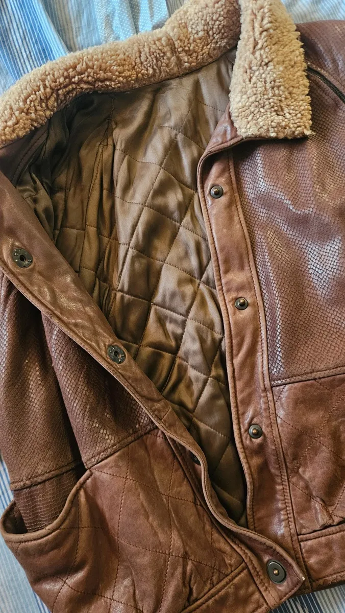 Cette veste VFORTI est confectionnée en cuir marron souple à motif serpenté. Les manches sont amovibles. Très bon état, avec quelques signes d'usure dus au temps. 7