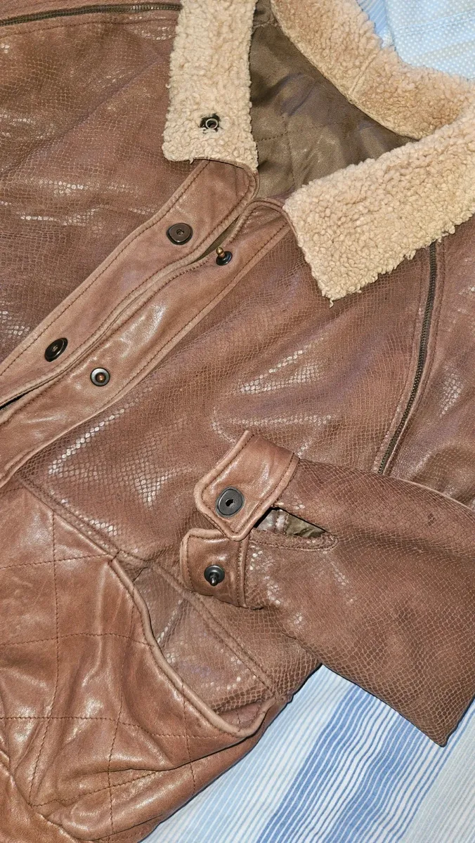 Cette veste VFORTI est confectionnée en cuir marron souple à motif serpenté. Les manches sont amovibles. Très bon état, avec quelques signes d'usure dus au temps. 4