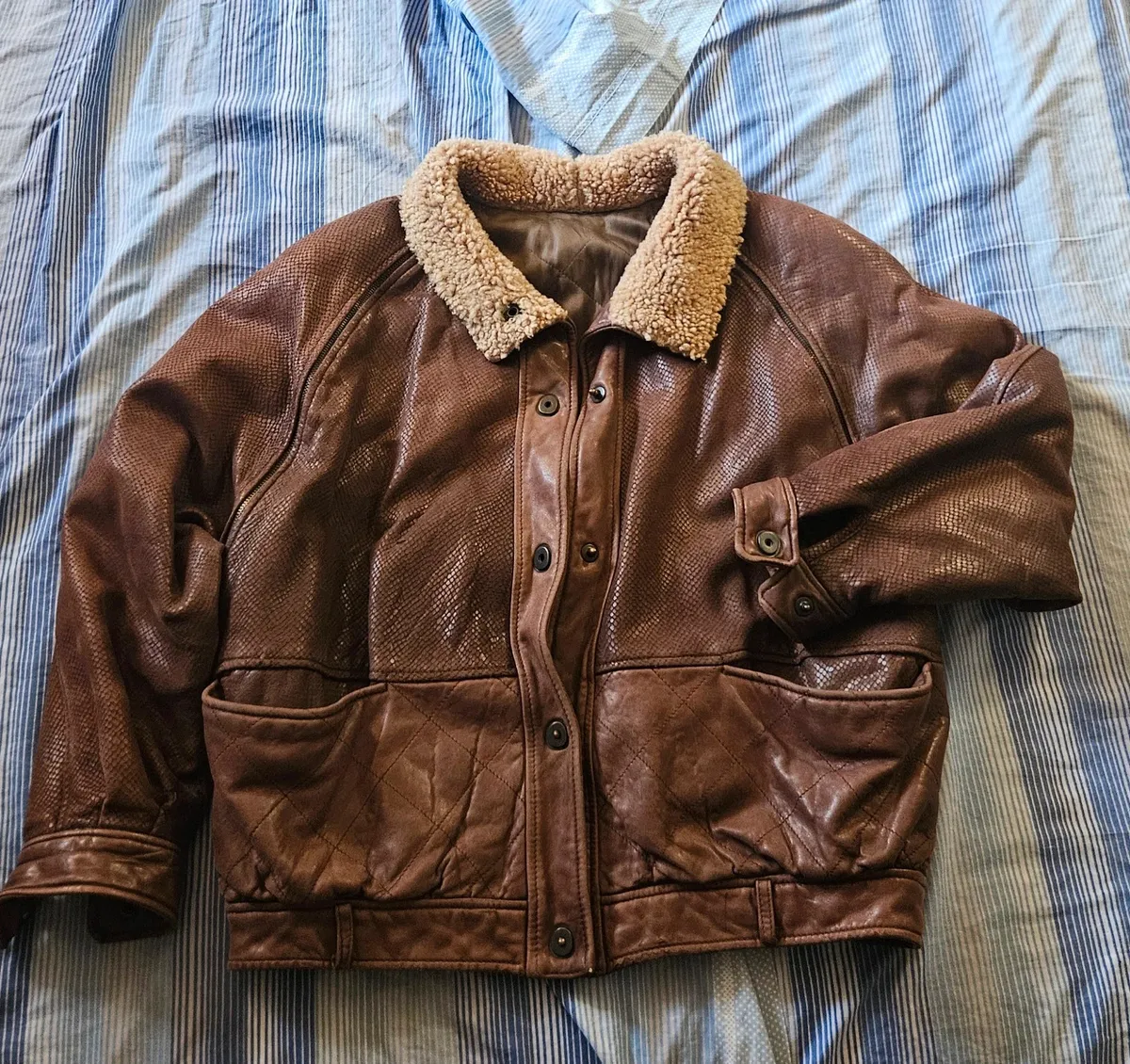 Cette veste VFORTI est confectionnée en cuir marron souple à motif serpenté. Les manches sont amovibles. Très bon état, avec quelques signes d'usure dus au temps. 2