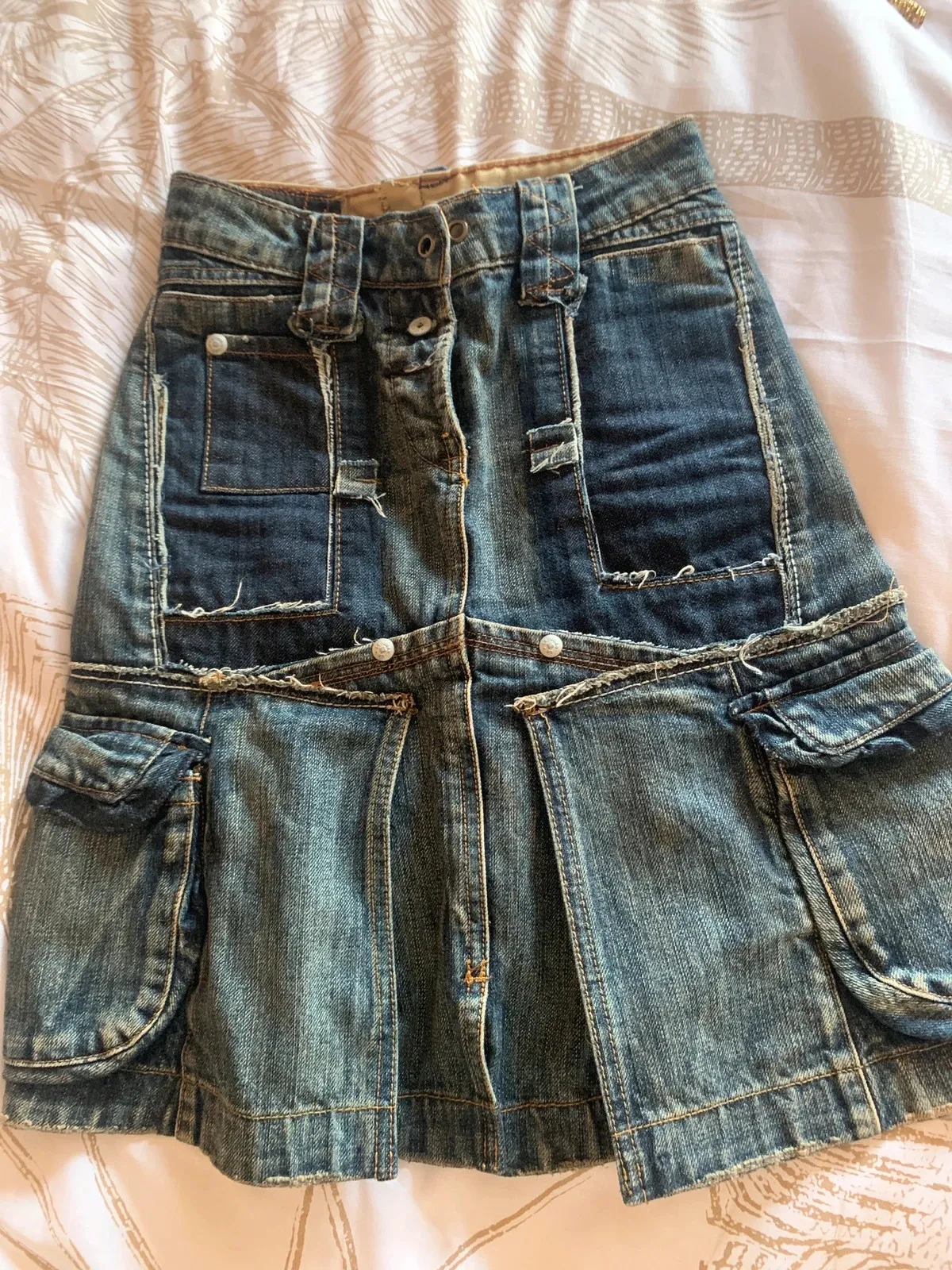 Size XXS — 32 cm flat
Rare model
Authentic denim skirt by Marithé + François Girbaud, with an original, detailed design.
Short cut with cargo details and a patchwork effect, typical of the brand.
✔️ Many pockets (front + sides)
✔️ Frayed details and visible seams for a vintage look
✔️ Thick, quality denim
✔️ Button closure / note one metal button is missing (see last photo) but it does not show when worn
✔️ Good overall condition / plan for a drawstring
Size XS
Colour: lightly faded denim blue
Perfect for a casual, streetwear or Y2K look. Easy to wear with a t-shirt, a tank top or a denim jacket. 1