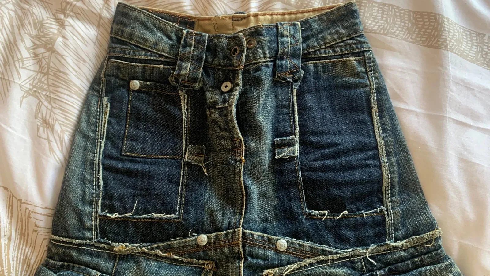Size XXS — 32 cm flat
Rare model
Authentic denim skirt by Marithé + François Girbaud, with an original, detailed design.
Short cut with cargo details and a patchwork effect, typical of the brand.
✔️ Many pockets (front + sides)
✔️ Frayed details and visible seams for a vintage look
✔️ Thick, quality denim
✔️ Button closure / note one metal button is missing (see last photo) but it does not show when worn
✔️ Good overall condition / plan for a drawstring
Size XS
Colour: lightly faded denim blue
Perfect for a casual, streetwear or Y2K look. Easy to wear with a t-shirt, a tank top or a denim jacket. 2