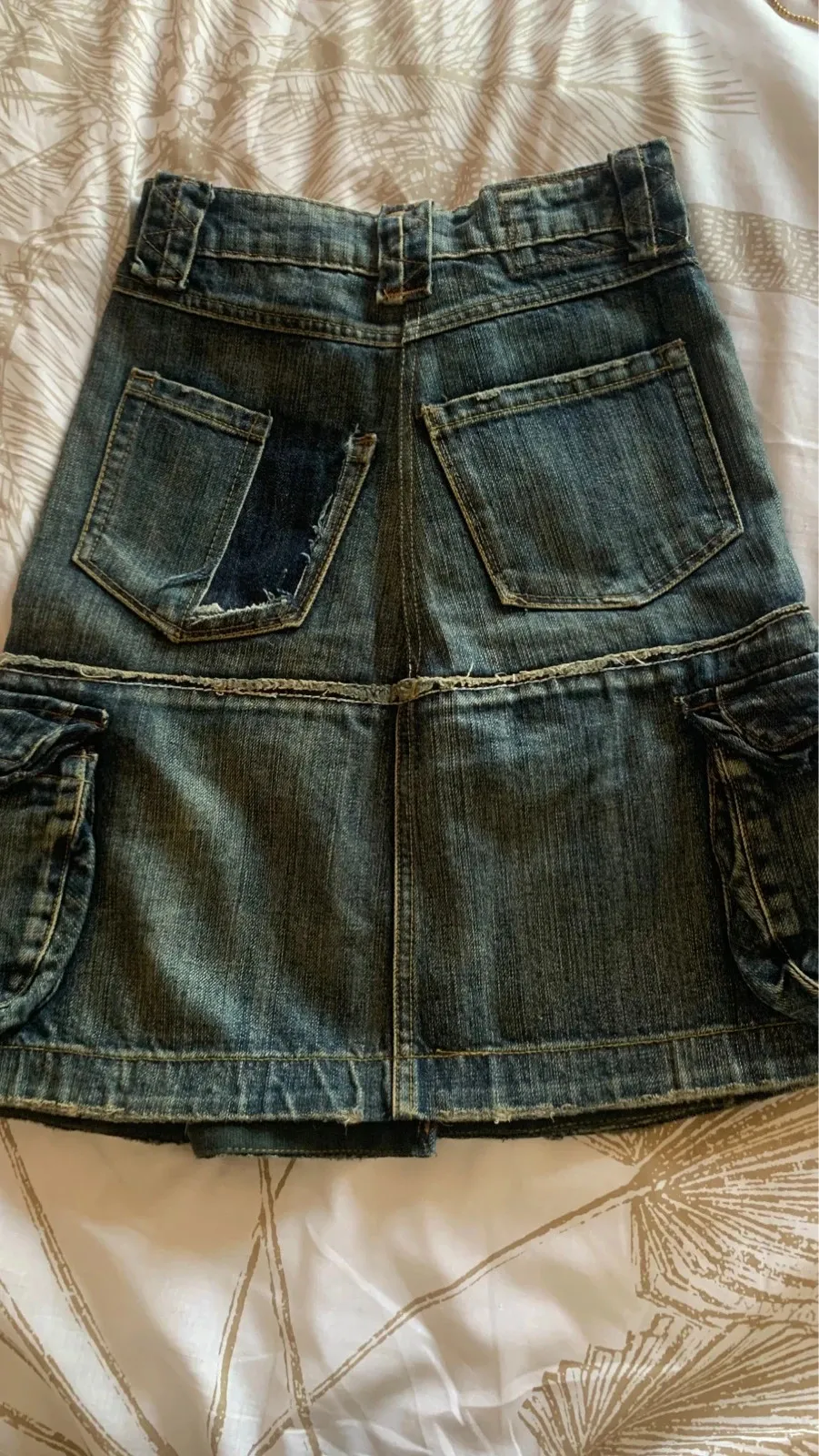 Size XXS — 32 cm flat
Rare model
Authentic denim skirt by Marithé + François Girbaud, with an original, detailed design.
Short cut with cargo details and a patchwork effect, typical of the brand.
✔️ Many pockets (front + sides)
✔️ Frayed details and visible seams for a vintage look
✔️ Thick, quality denim
✔️ Button closure / note one metal button is missing (see last photo) but it does not show when worn
✔️ Good overall condition / plan for a drawstring
Size XS
Colour: lightly faded denim blue
Perfect for a casual, streetwear or Y2K look. Easy to wear with a t-shirt, a tank top or a denim jacket. 4