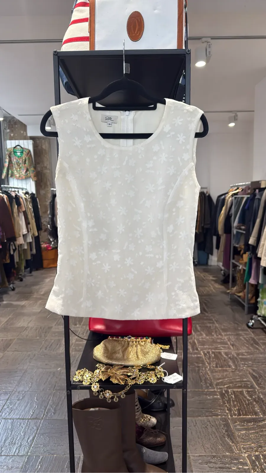 Ecru sleeveless top with textured floral pattern and back zip.