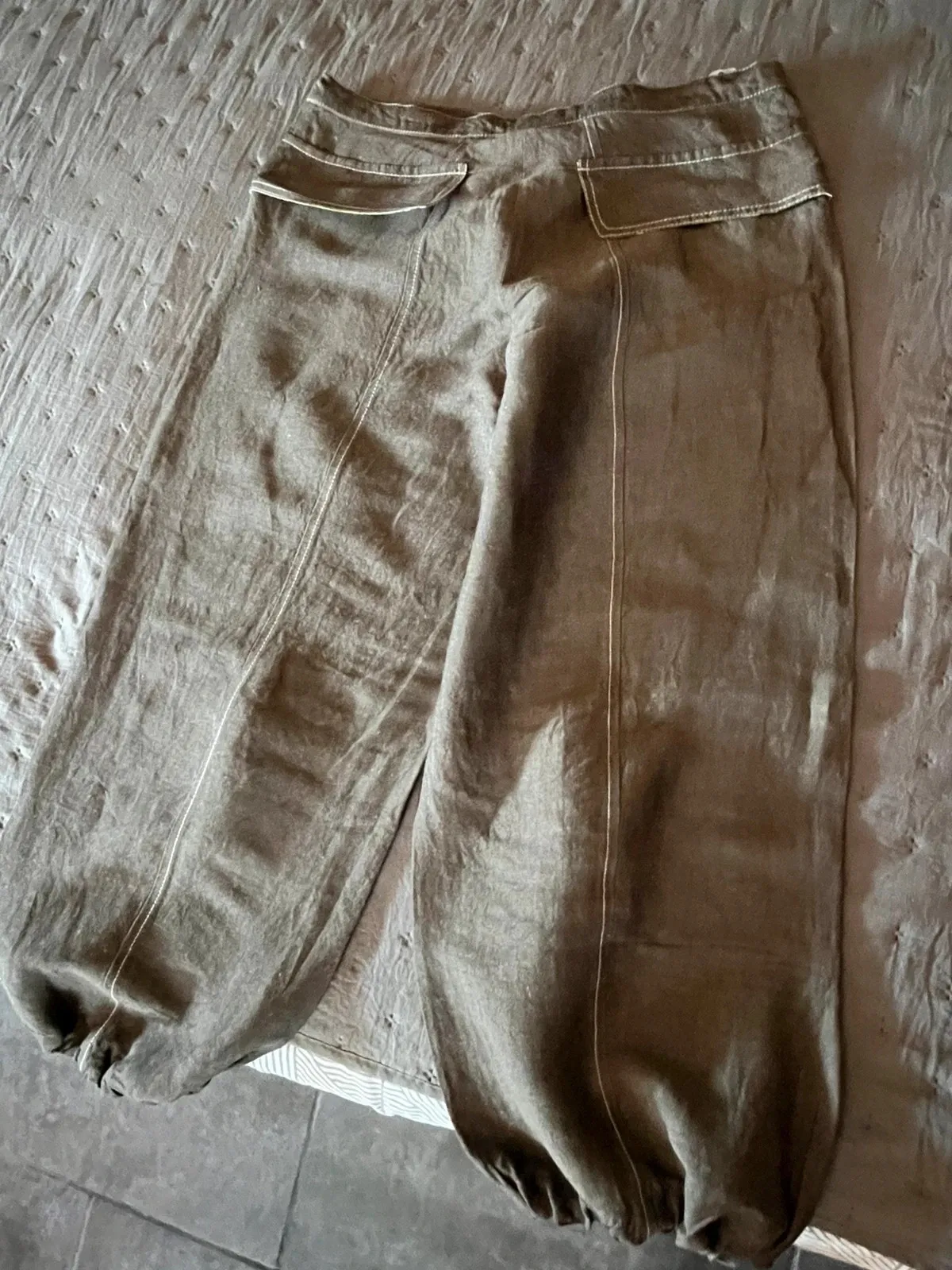 Très beau pantalon original, hauteur chevilles. Deux grandes poches zippées devant avec motifs fleuris à l'intérieur. Quelques pinces aux niveaux des genoux. Deux fausses poches à l'arrière avec motifs floraux à l'intérieur du rabat. Lien de serrage au bas des jambes. Taille à plat 40 cms, longueur ceinture à l'entrejambe 31 cms, longueur totale du pantalon 84 cms. Couleur chocolat au lait. 8
