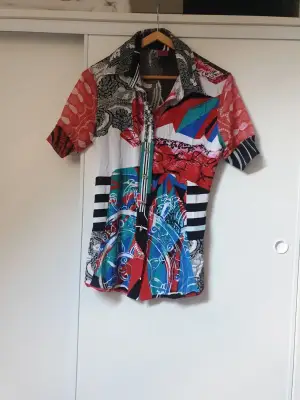 Splendide chemise de la célèbre marque italienne Save the queen. Des couleurs chatoyantes pour démarrer l'été. Agréable et confortable pour un look tendance et original. De nombreux détails propres à la marque. Un bijou. Quasi neuf car peu porté.

Envoi uniquement par chronopost et colissimo.