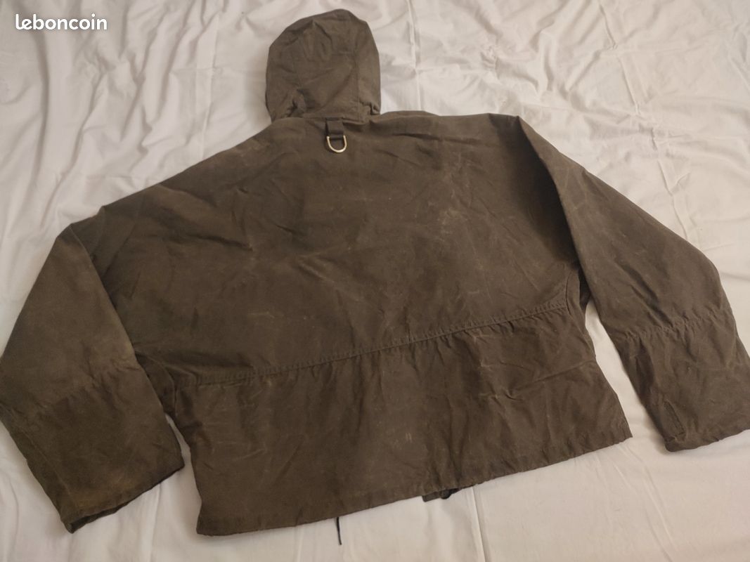 Blouson ou veste courte huilé de la marque FILSON A Genuine C.C. FILSON CO. SEATTLE.
Avec deux poches à l'extérieur et deux poches protège mains, une poche à l'intérieur.
Le bout des manches est tricoté et doublé. Capuche avec lacet de serrage. En parfait état.
C'est une taille L. 3