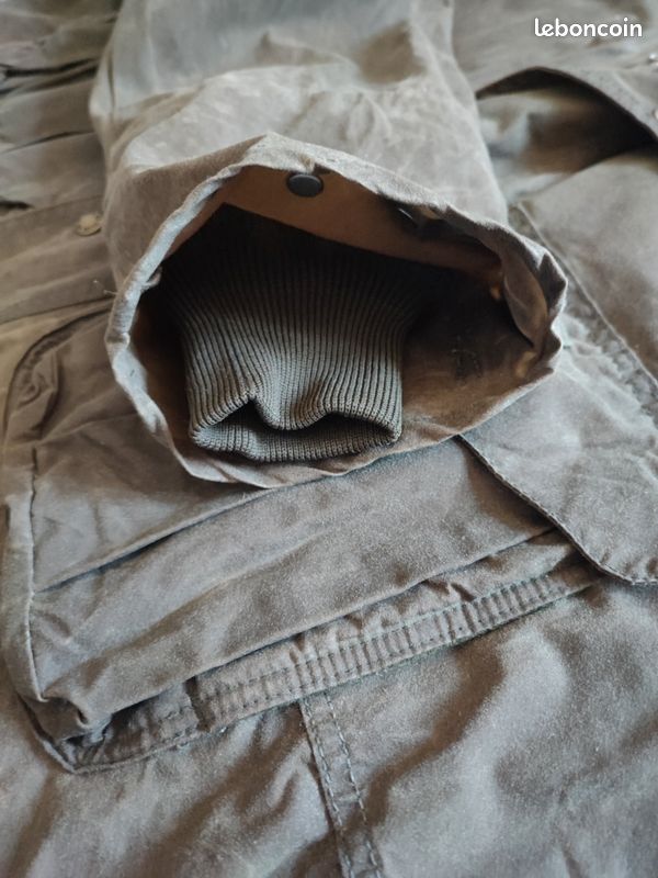 Blouson ou veste courte huilé de la marque FILSON A Genuine C.C. FILSON CO. SEATTLE.
Avec deux poches à l'extérieur et deux poches protège mains, une poche à l'intérieur.
Le bout des manches est tricoté et doublé. Capuche avec lacet de serrage. En parfait état.
C'est une taille L. 12