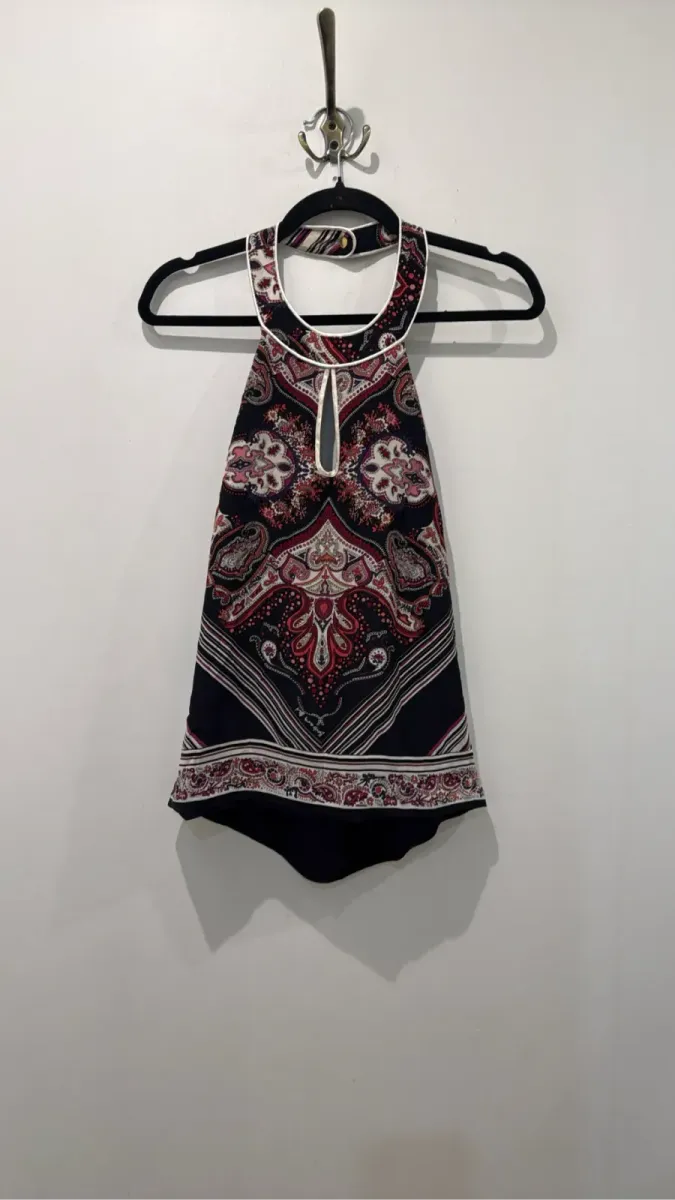 Black women's top with multicoloured paisley pattern, halter neck and teardrop detail.