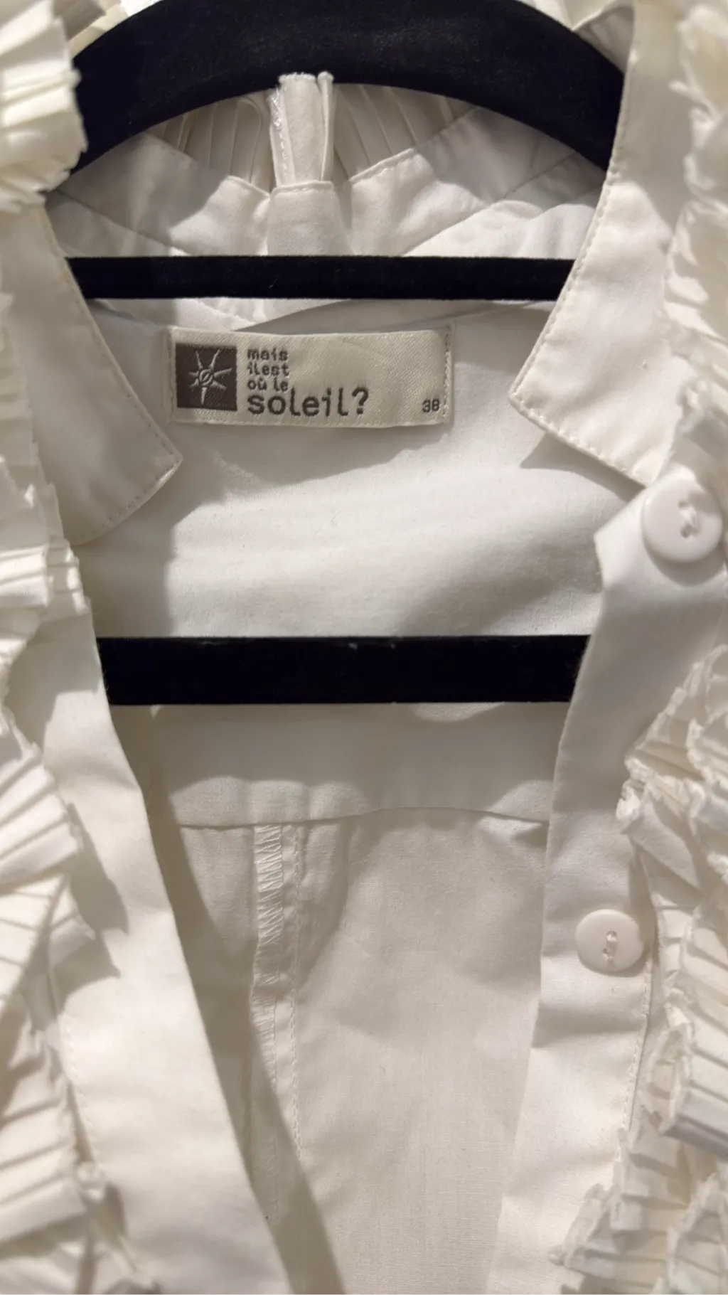 Blouse blanche à manches longues avec un grand col et des volants plissés sur le devant. 2