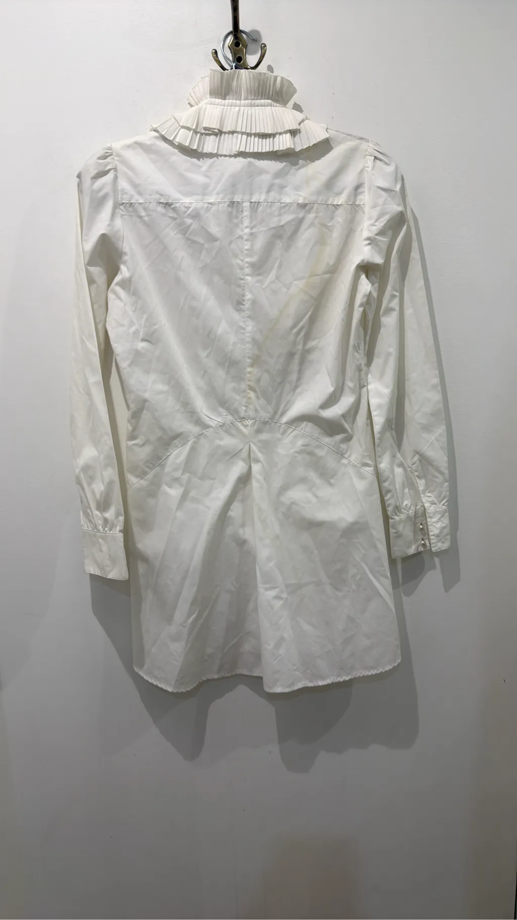 Blouse blanche à manches longues avec un grand col et des volants plissés sur le devant. 5