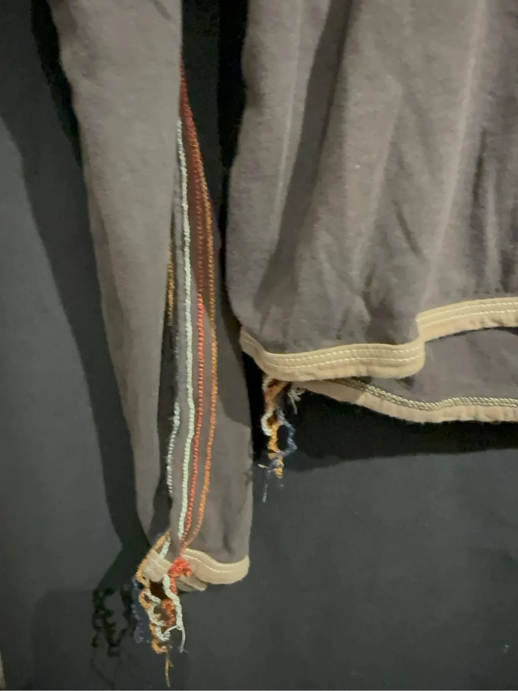 Haut à manches longues en coton anthracite avec col bénitier beige, coutures apparentes multicolores et bords effilochés. 3