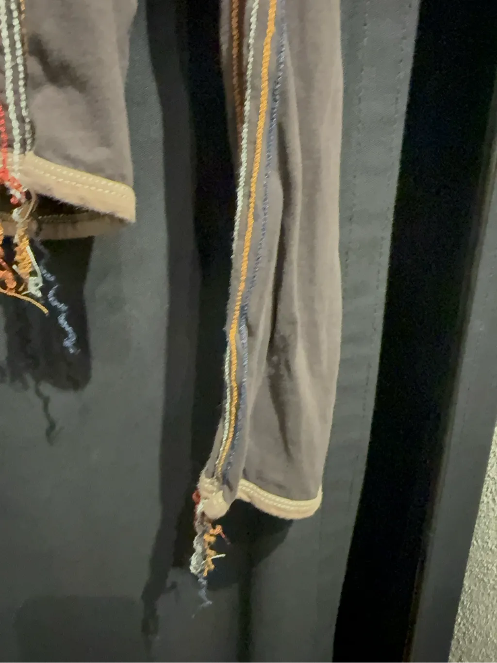 Haut à manches longues en coton anthracite avec col bénitier beige, coutures apparentes multicolores et bords effilochés. 4