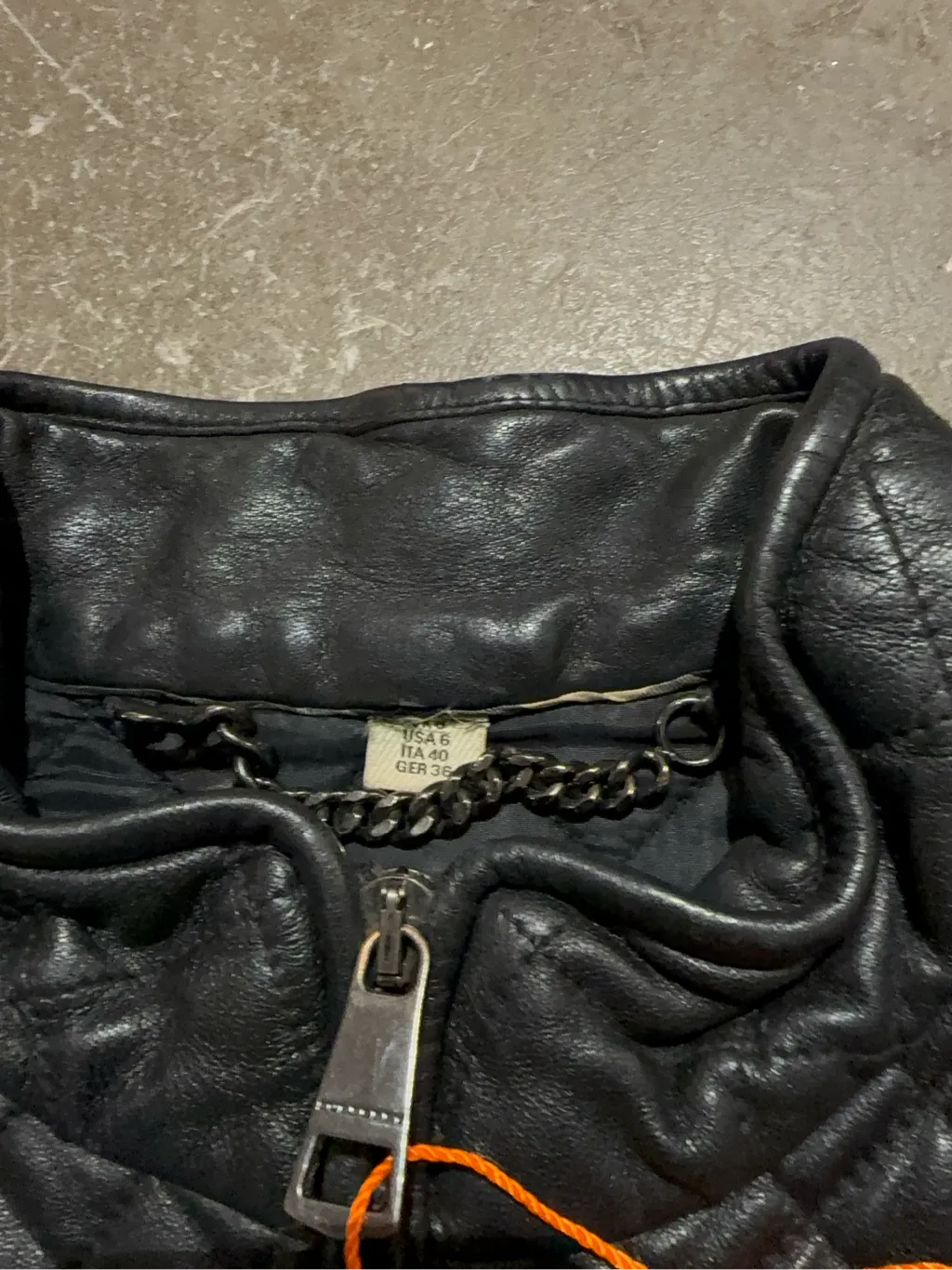 Veste matelassée en cuir noir pour femme avec fermeture éclair et détails côtelés. 4