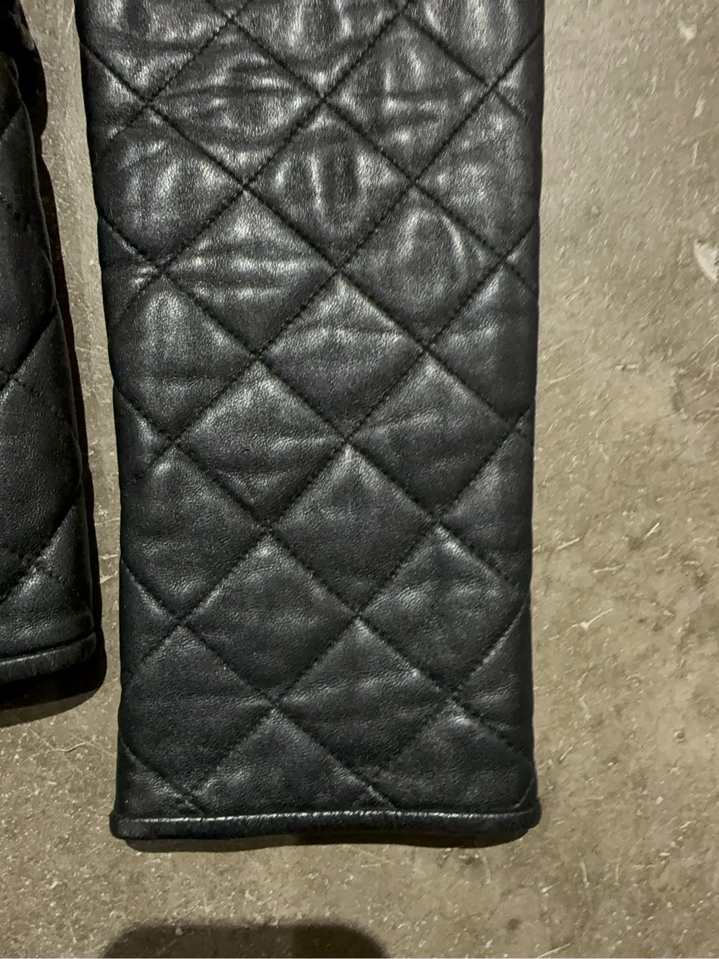 Veste matelassée en cuir noir pour femme avec fermeture éclair et détails côtelés. 5