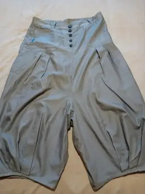Jupe sarouel avec fronces en bas de chaque jambe, fronces plates sur le devant 
2 poches arrières 
Boutonnières devant 
Taille 42  de chez cop copine 
Très bon état  tissu  souple et fin ,gris clair