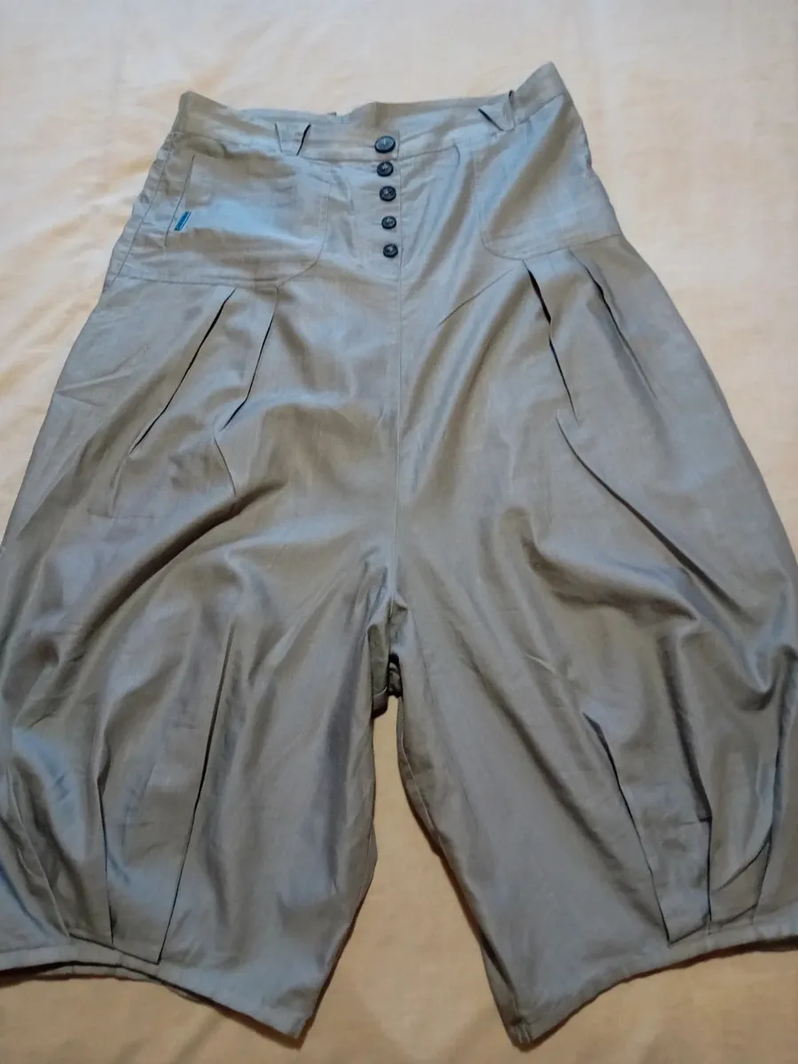 Jupe sarouel avec fronces en bas de chaque jambe, fronces plates sur le devant
2 poches arrières
Boutonnières devant
Taille 42 de chez cop copine
Très bon état tissu souple et fin ,gris clair