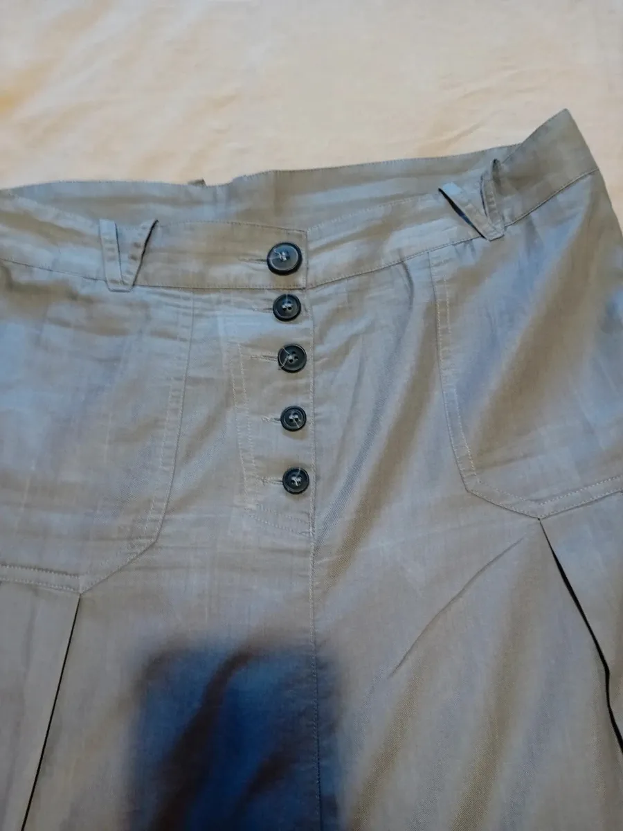 Jupe sarouel avec fronces en bas de chaque jambe, fronces plates sur le devant
2 poches arrières
Boutonnières devant
Taille 42 de chez cop copine
Très bon état tissu souple et fin ,gris clair 4
