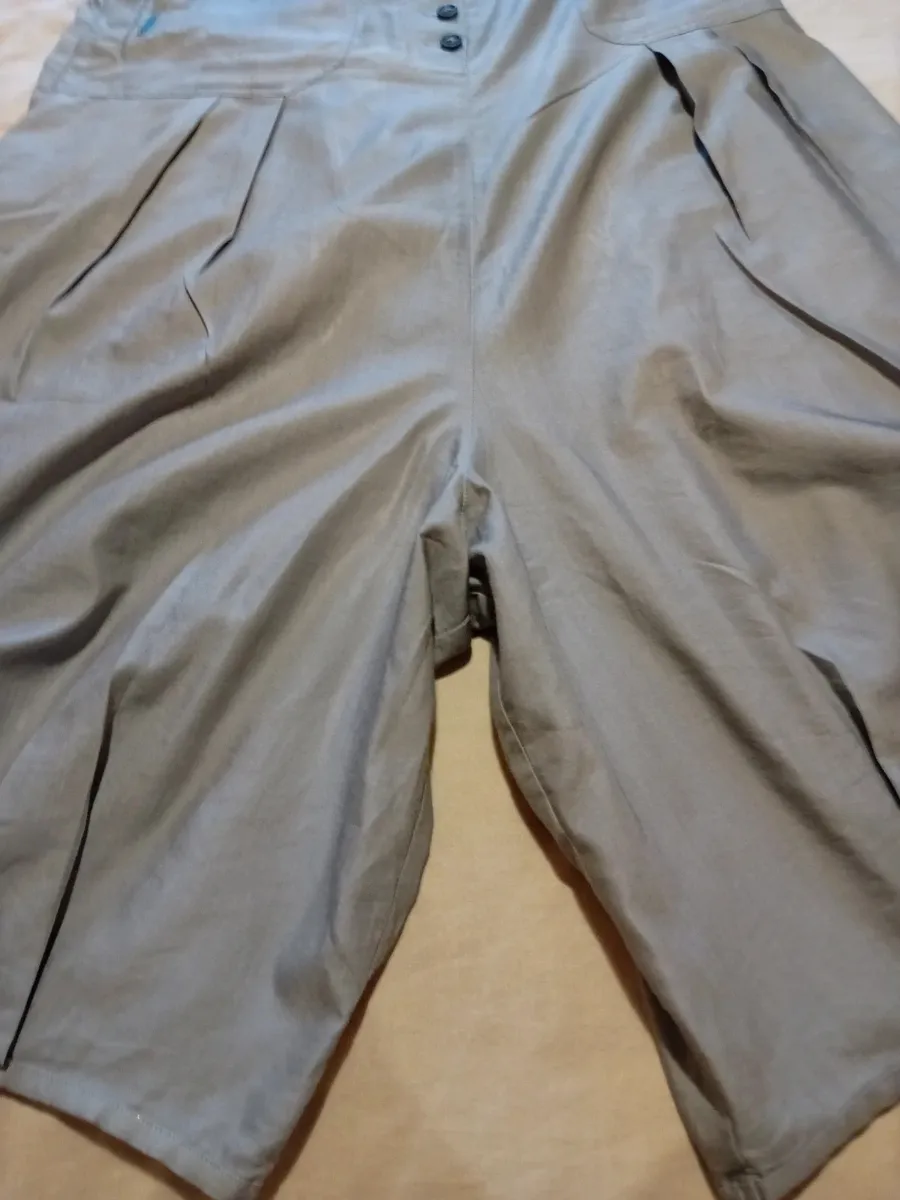 Jupe sarouel avec fronces en bas de chaque jambe, fronces plates sur le devant
2 poches arrières
Boutonnières devant
Taille 42 de chez cop copine
Très bon état tissu souple et fin ,gris clair 2