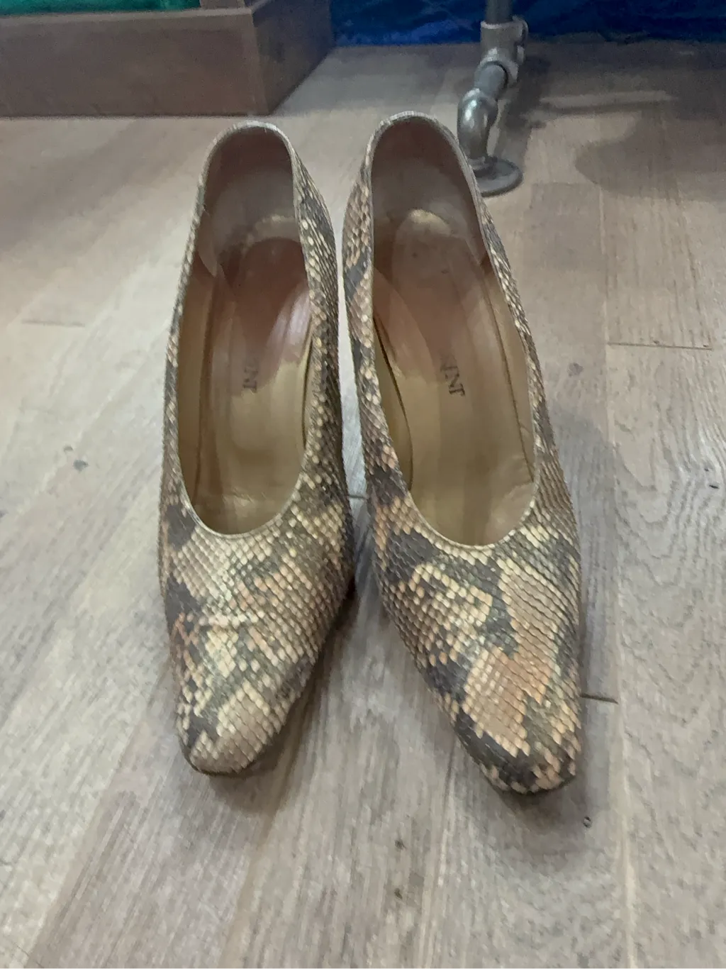 Escarpins en cuir imprimé serpent beige et marron avec talons épais, montrant une usure visible sur les semelles intérieures et les talons.