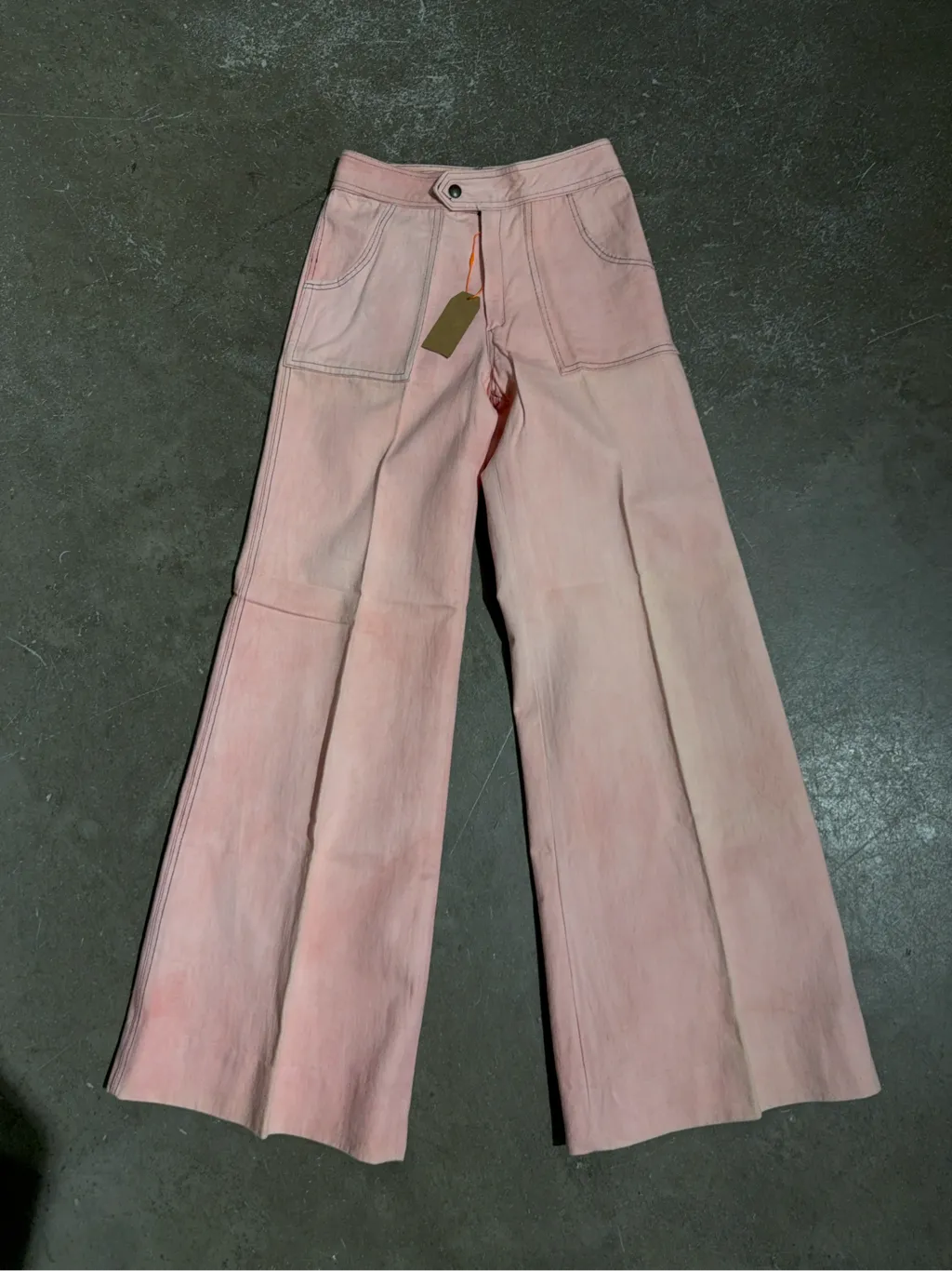 Pantalon évasé rose en coton teint à la main avec surpiqûres contrastantes.