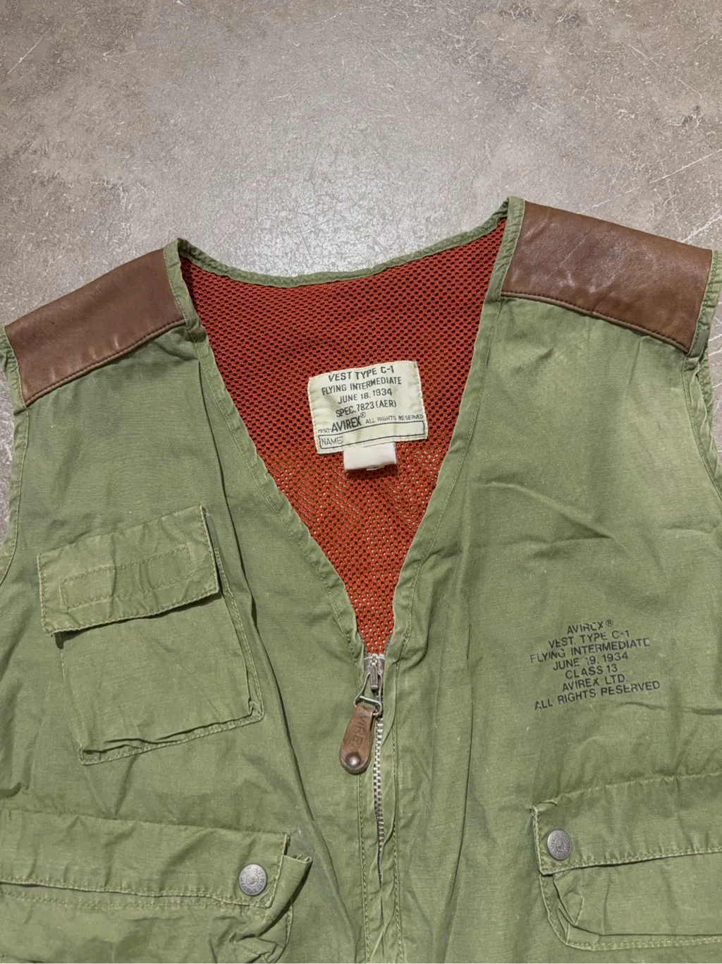 Gilet utilitaire vert kaki Avirex inspiré des vestes de vol C-1 de 1934, avec de multiples poches et des détails en cuir marron. 4