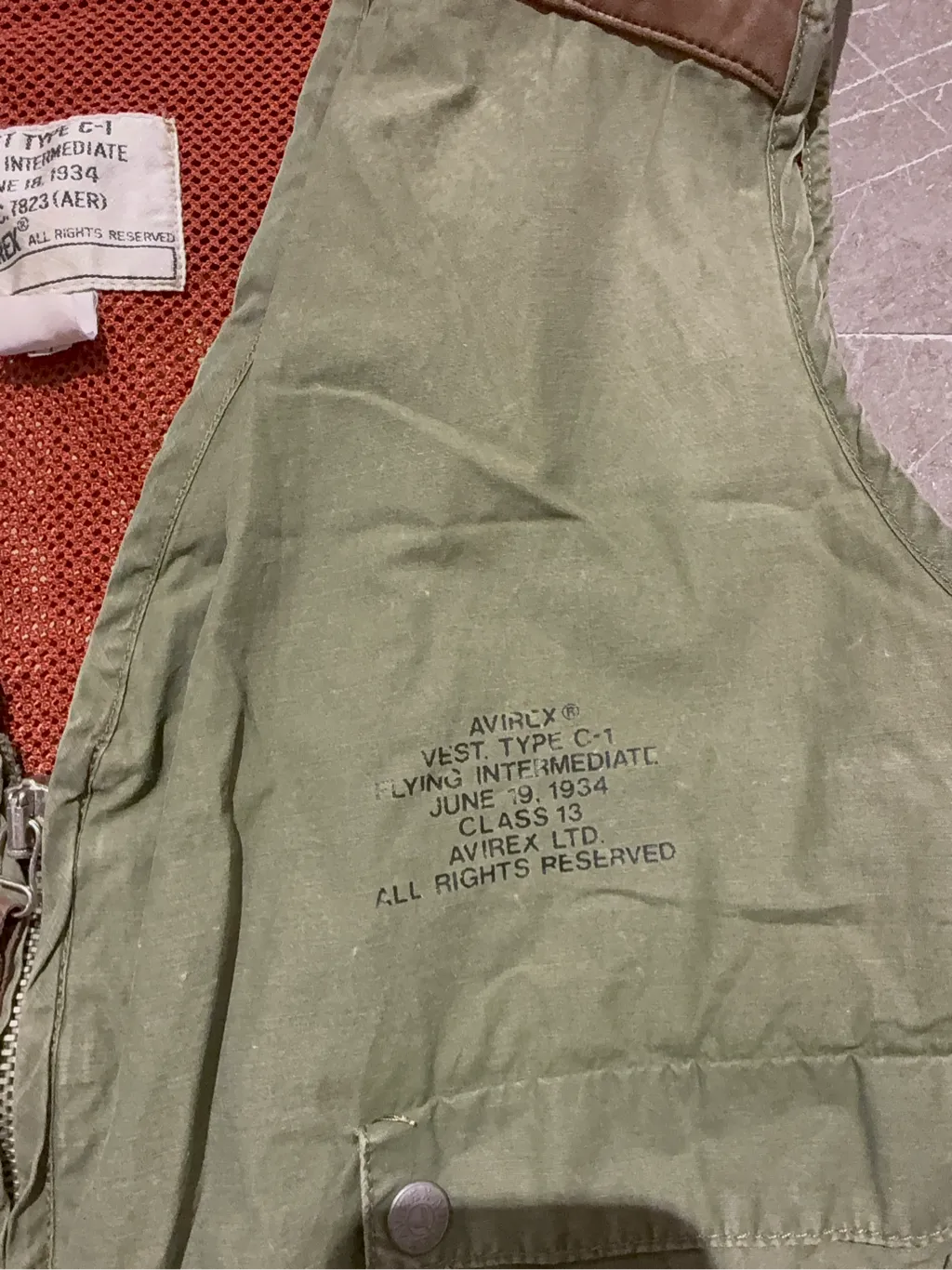 Gilet utilitaire vert kaki Avirex inspiré des vestes de vol C-1 de 1934, avec de multiples poches et des détails en cuir marron. 5