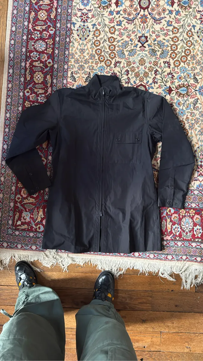 Veste longue noire zippée avec col montant et poche poitrine, de la ligne Pour Homme de Yohji Yamamoto.