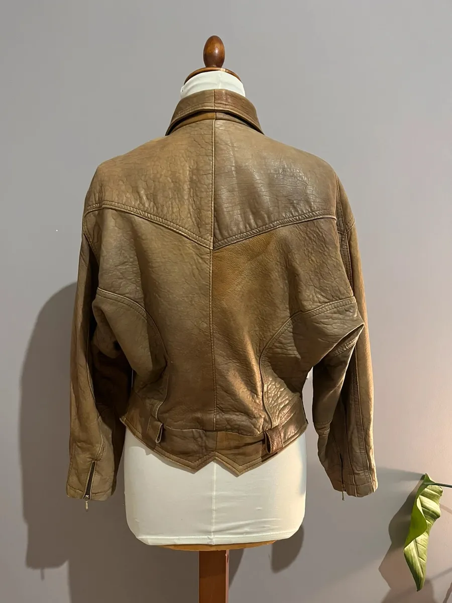 Cuir véritable. Vintage. Modèle bomber.Présente les usures typiques des vêtements vintage mais aucun défaut particulier. 2