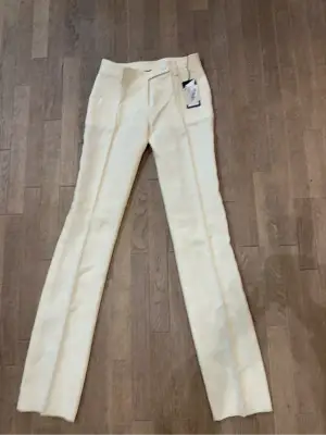 Pantalon Versace écru neuf avec étiquettes, coupe droite et ajustée, fabriqué en Italie.