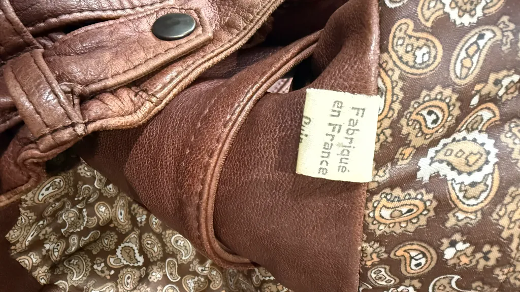 Brown leather aviator jacket with stand-up collar, asymmetrical snap button closure and quilted details. Inspired by Girbaud Sicons Giorgio Armani 6