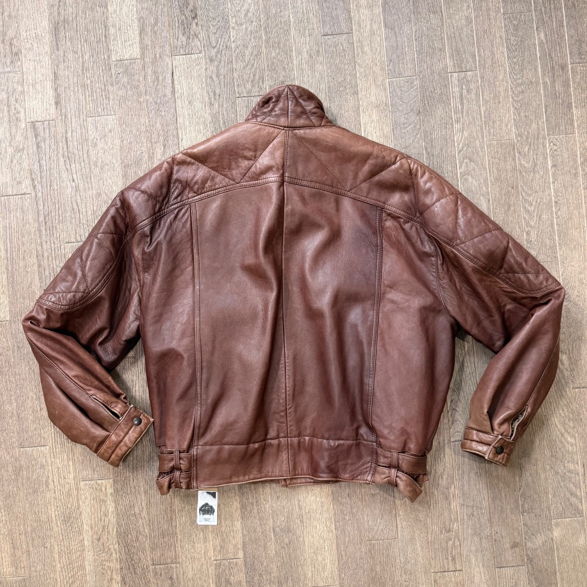 Brown leather aviator jacket with stand-up collar, asymmetrical snap button closure and quilted details. Inspired by Girbaud Sicons Giorgio Armani 3
