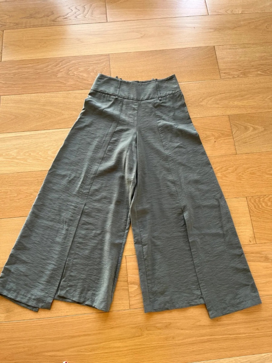 Pantalon taille haute, fendu sur l’avant et asymétrique cop.copine. Excellent état, Taille 38. Arrive à mi mollet.